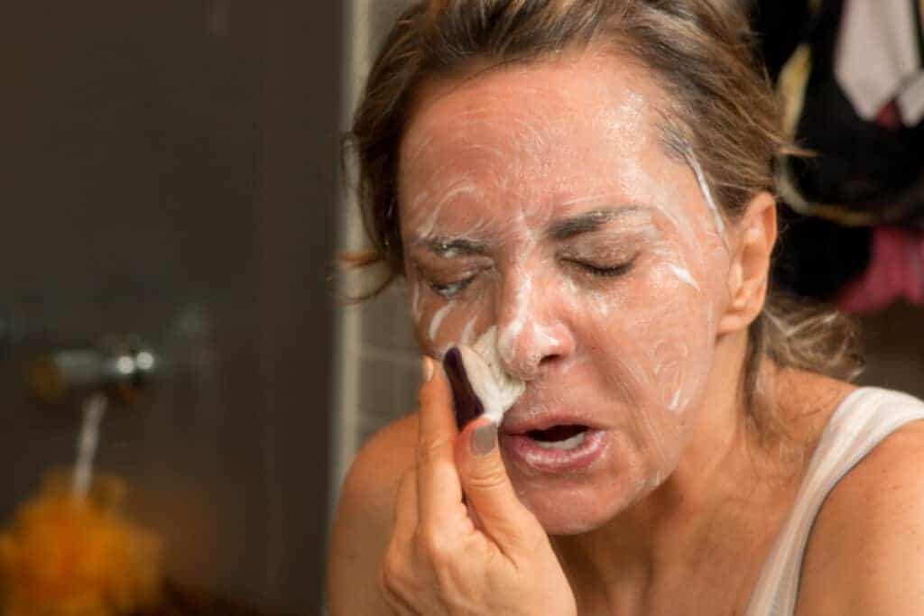 woman scrubbing her face with soap