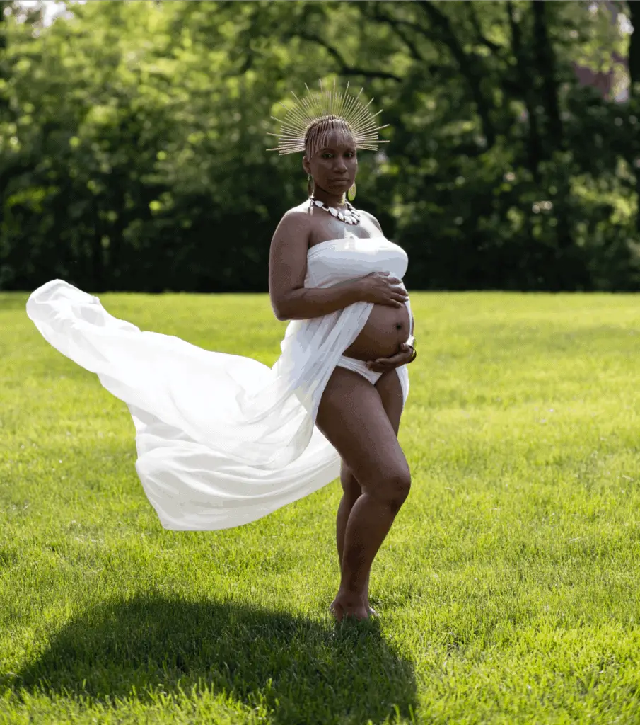 pregnant woman standing in grass field