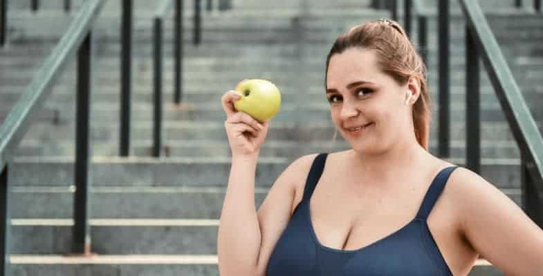 plus size woman holding an apple