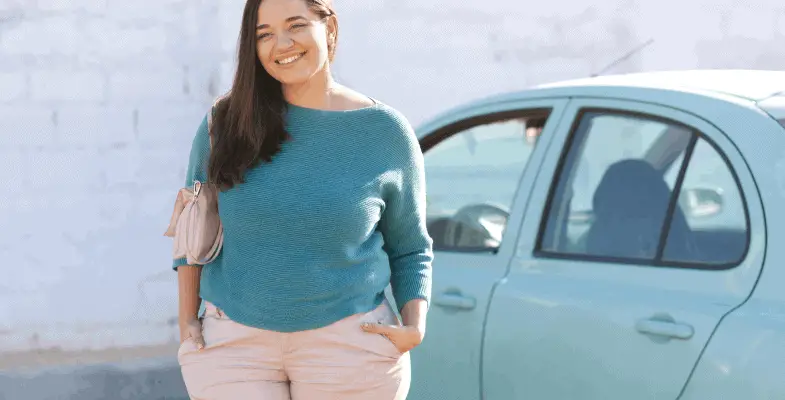 plus size woman standing next to her car